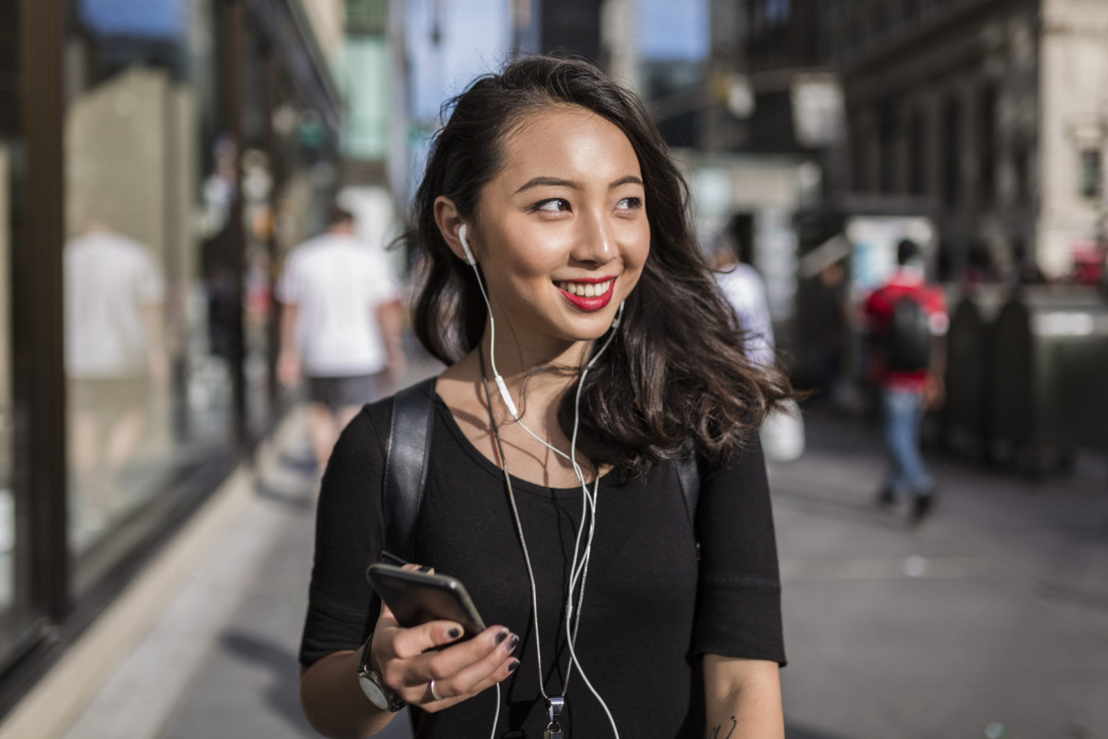 Young Asian woman using cellphone on Manhattan street